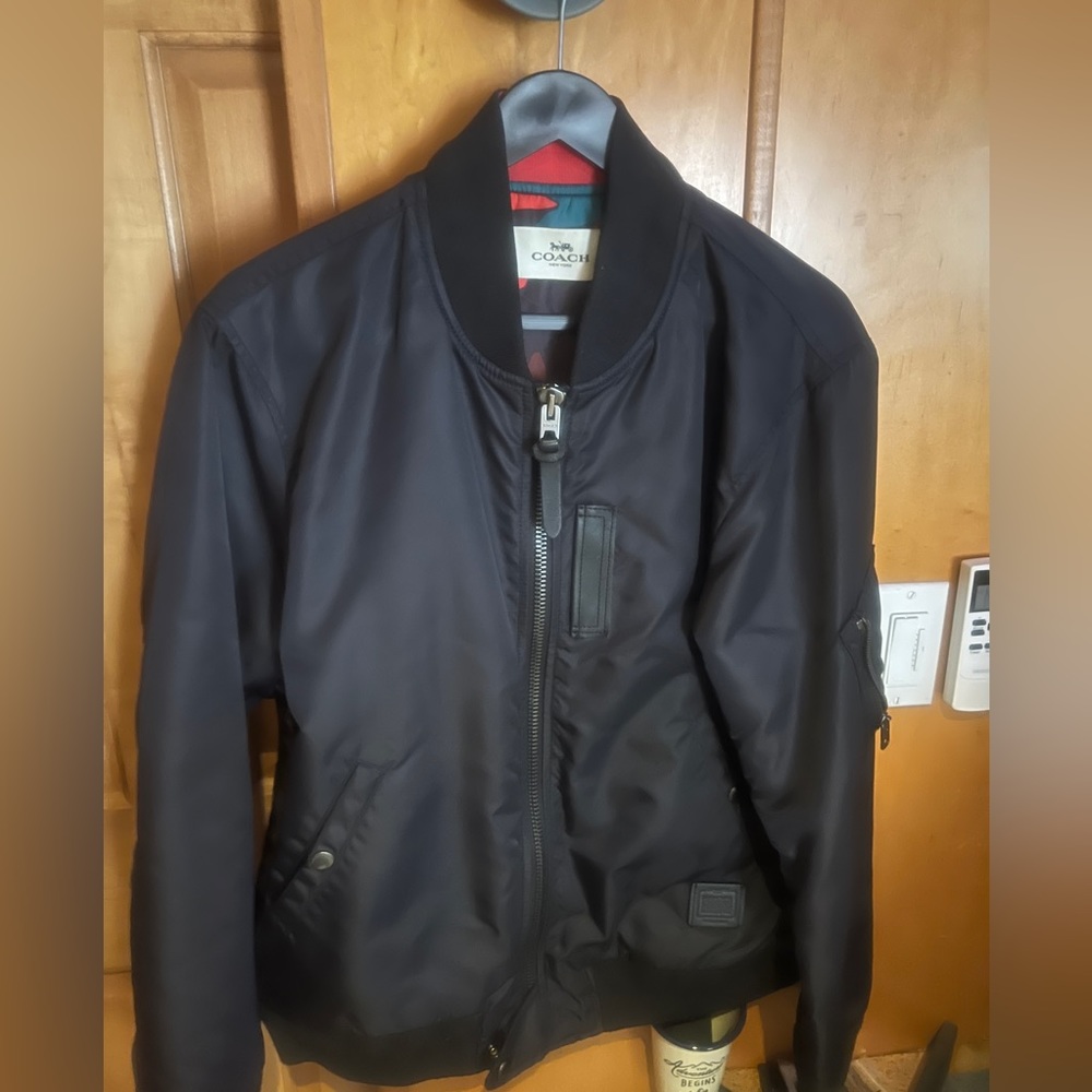 Coach Bomber Jacket, size medium, black outside with camouflage pattern inside.